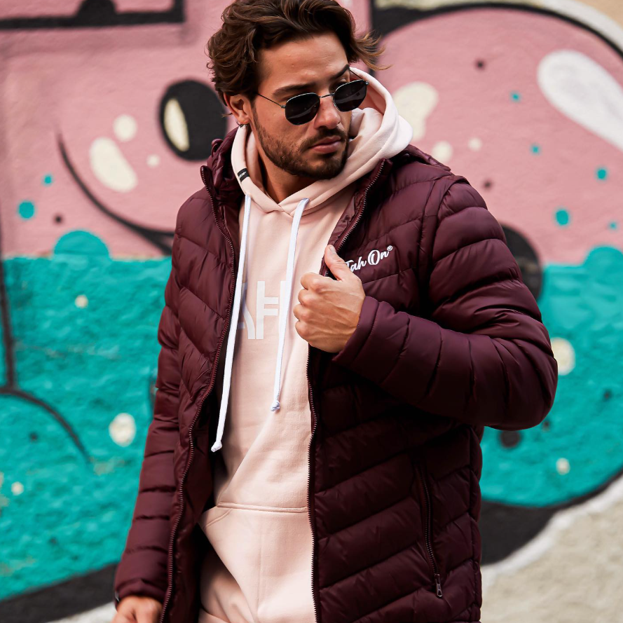 Editorial TAH ON — jaqueta puffer vinho sobre hoodie rosé em frente a grafite